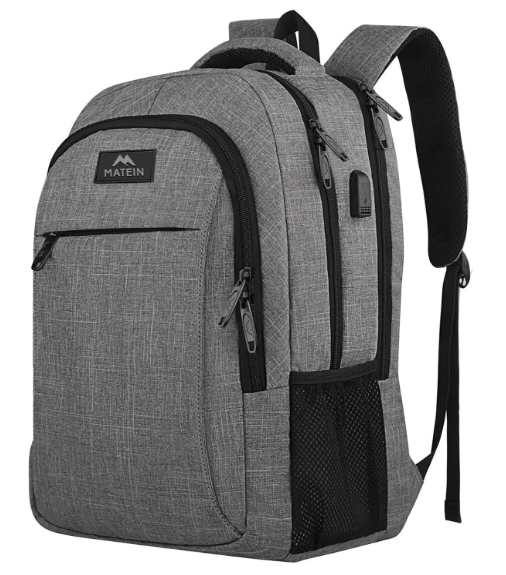 A grey Matein backpack with a sleek, modern design, featuring multiple zippered compartments, a front pocket, and a mesh side pocket. The backpack includes padded shoulder straps and a built-in USB charging port, making it suitable for travel, school, or work.